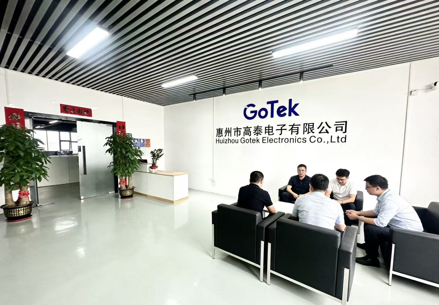 Modern electronics manufacturing facility interior with advanced production equipment, workers in cleanroom suits operating machinery, showcasing high-tech manufacturing environment